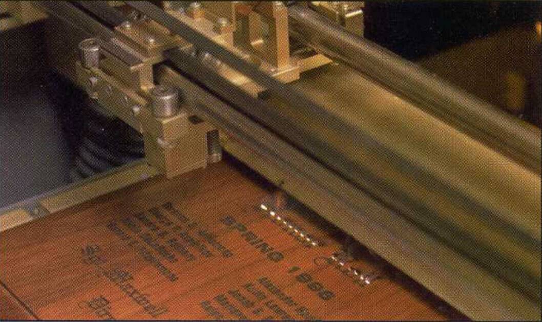 A wooden plaque is engraved by APS machinery.